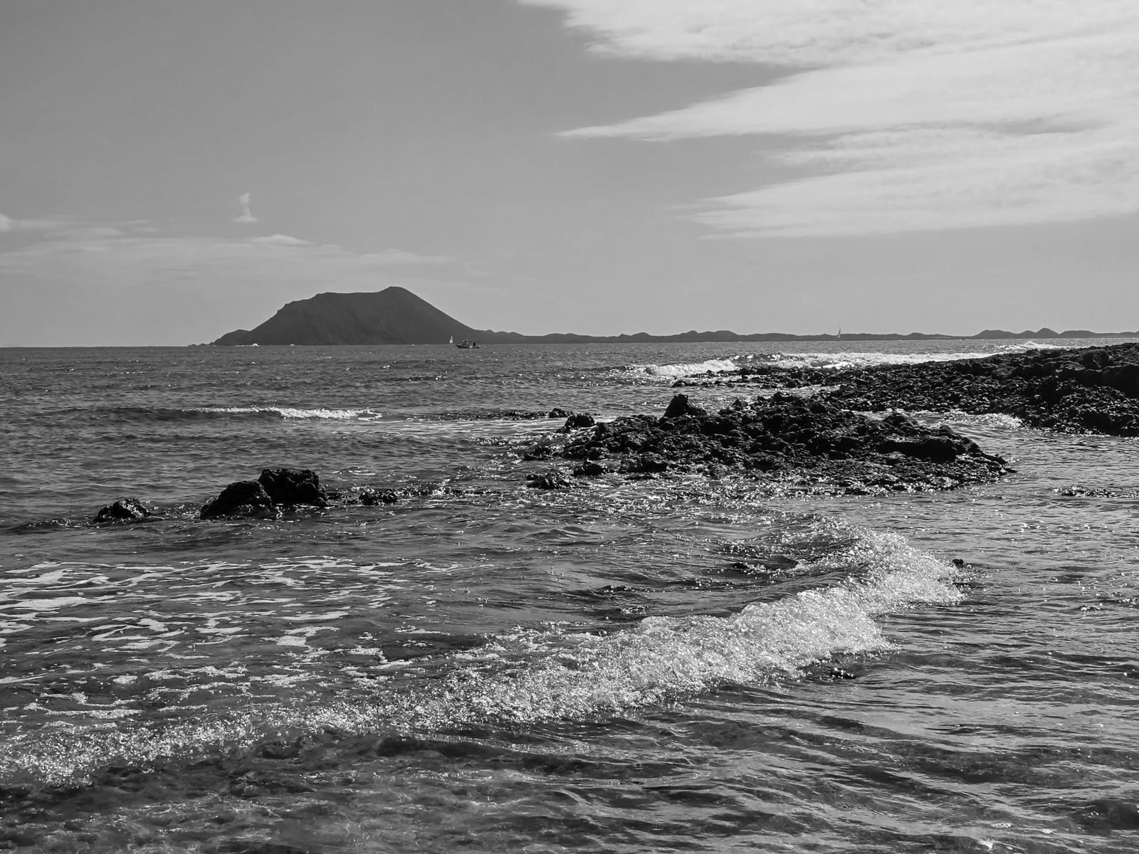 Black and white waves over volcanic rocks